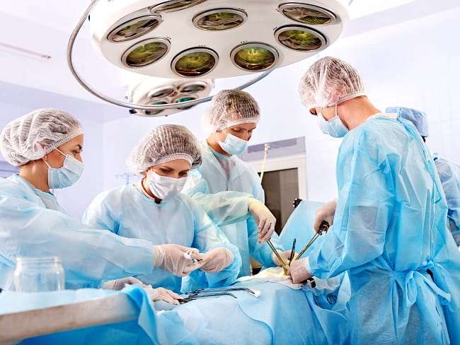 médicos cirurgiões realizando cirurgia para radiculopatia lombar