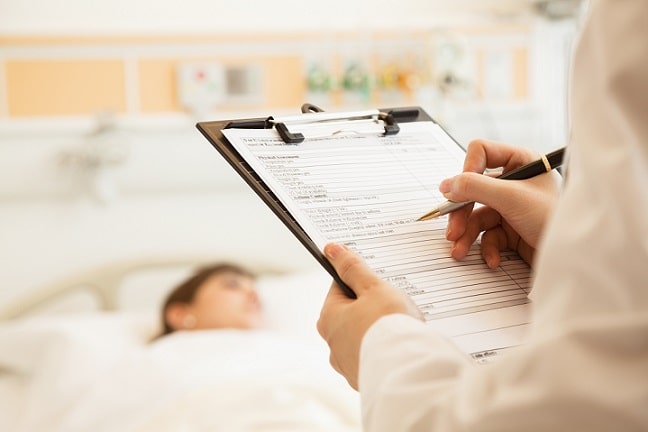 médico anotando em prontuário de paciente se preparando para intubação acordado