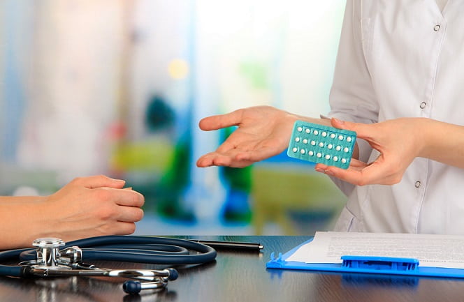 médica falando com paciente sobre comprimido para terapia de reposição hormonal