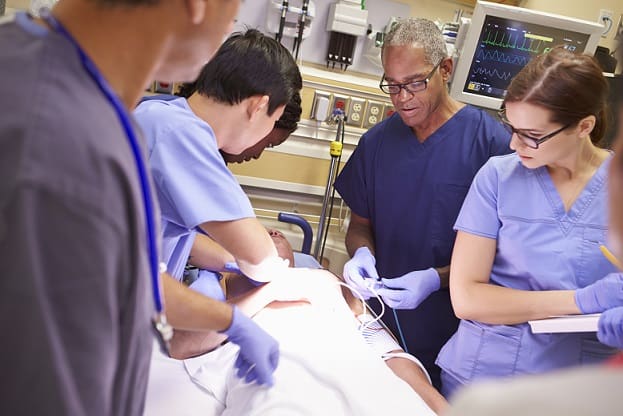 Paciente passando por infarto do miocárdio e equipe médica preparando a injeção de estatina