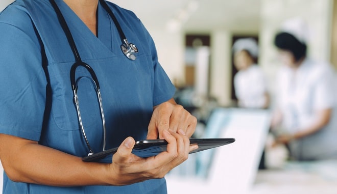 médico segurando prancheta em hospital antes de atender paciente com doença renal crônica