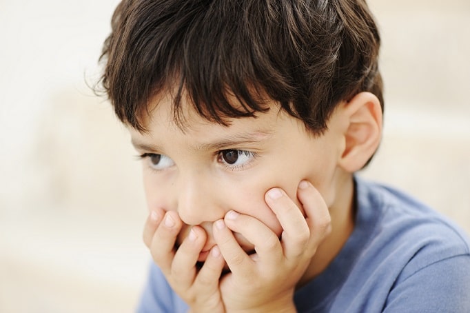 paciente autista com as mãos no rosto antes de consulta sobre função visual