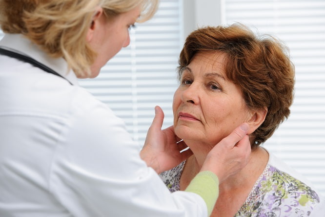 médica avaliando tireoide de paciente com possível câncer