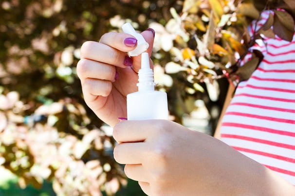 mão de menina segurando escetamina, medicamento intranasal